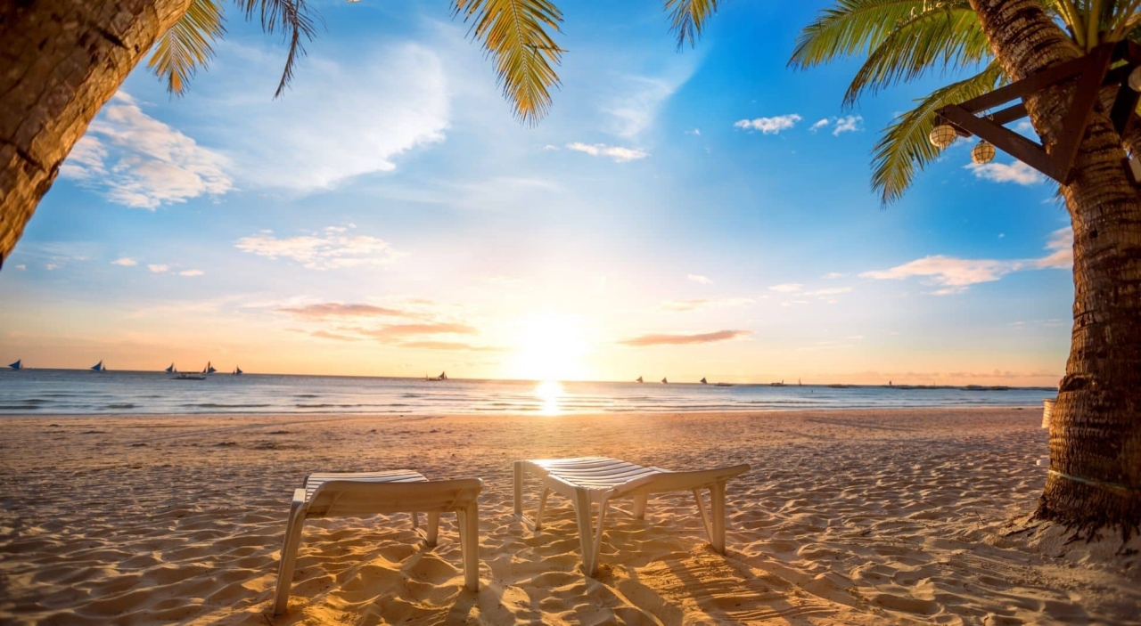 vacation scene of empty lounge chairs on a beach